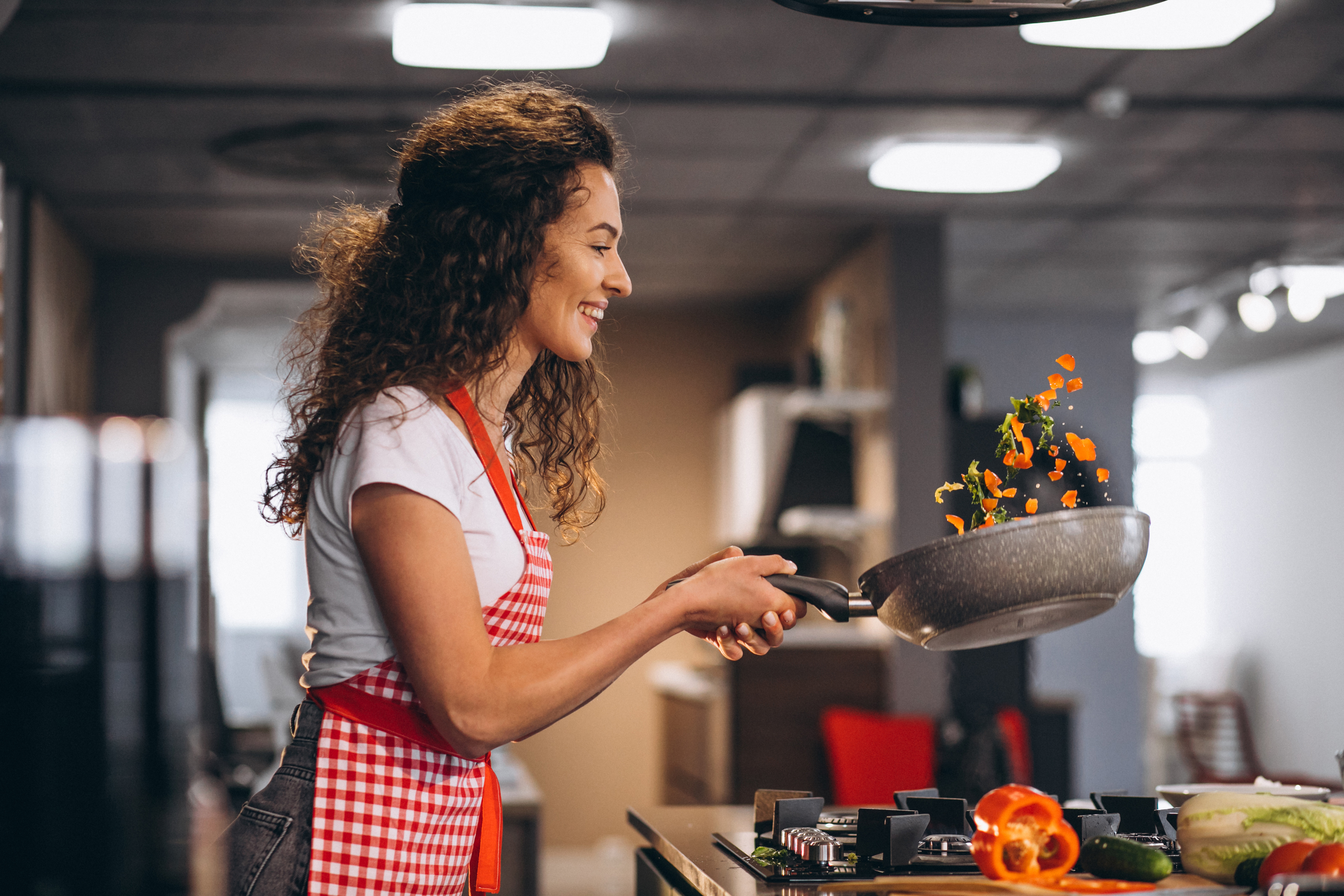 woman-chef-cooking-vegetables-in-pan