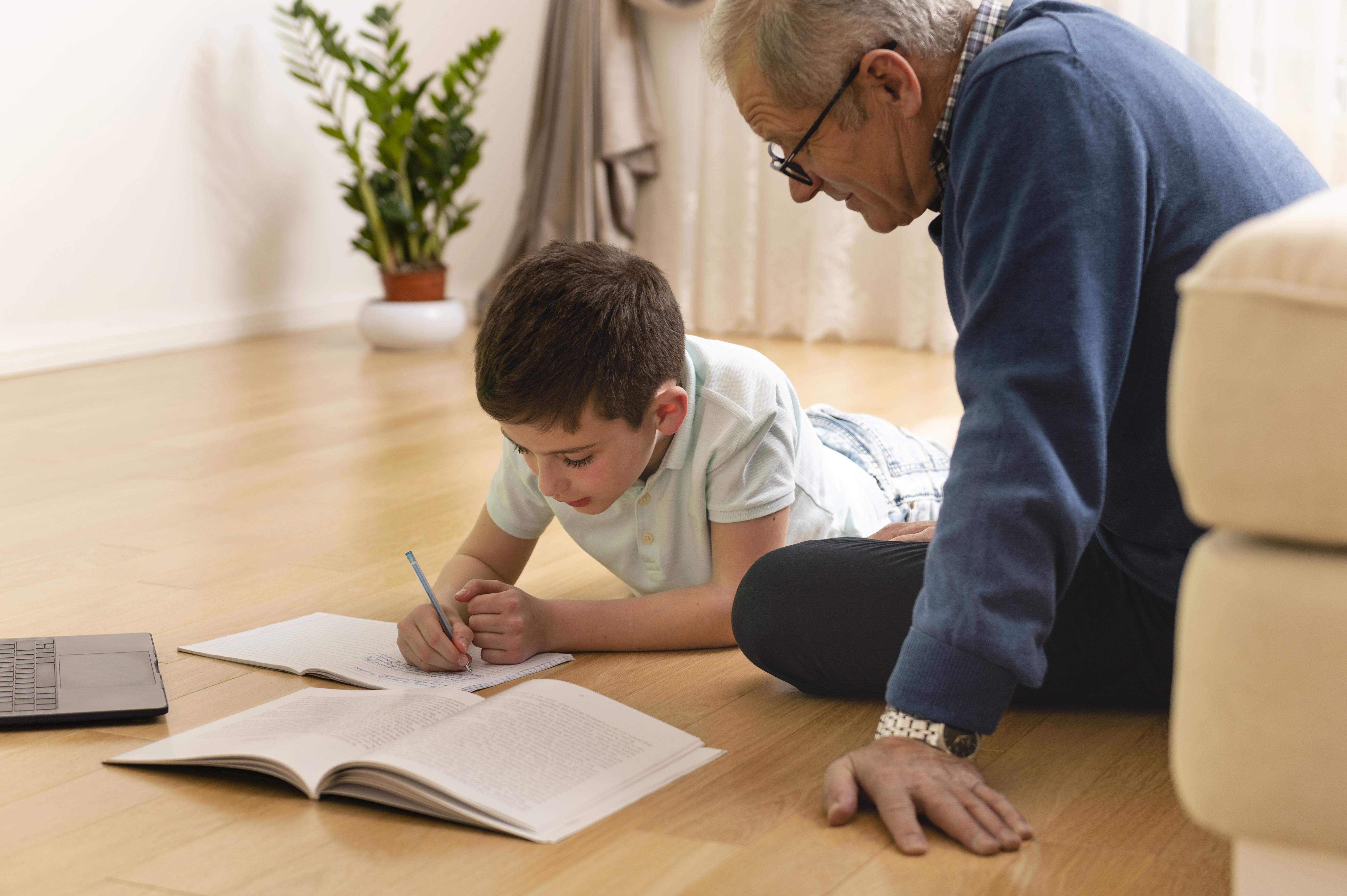 little-boy-doing-homework-with-his-grandfather-home